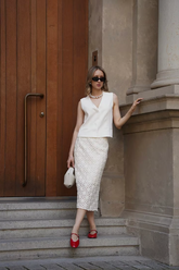 a lady in a white top and a white lace dress